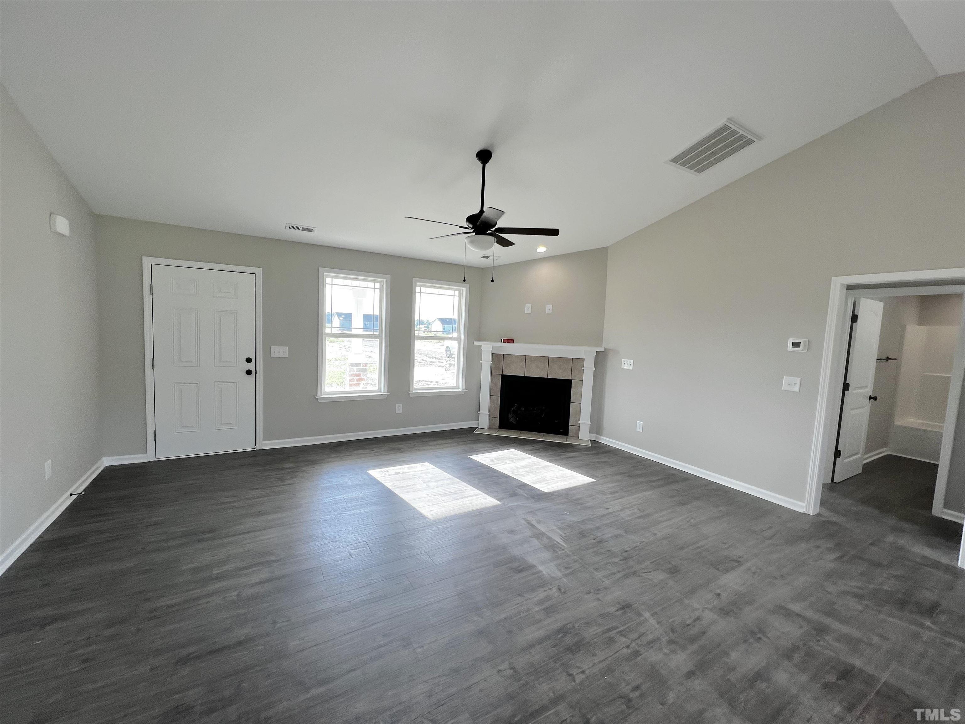 96 Mamie Road Benson, NC 27504 - Photo 5 of 20 an empty room with fireplace and windows