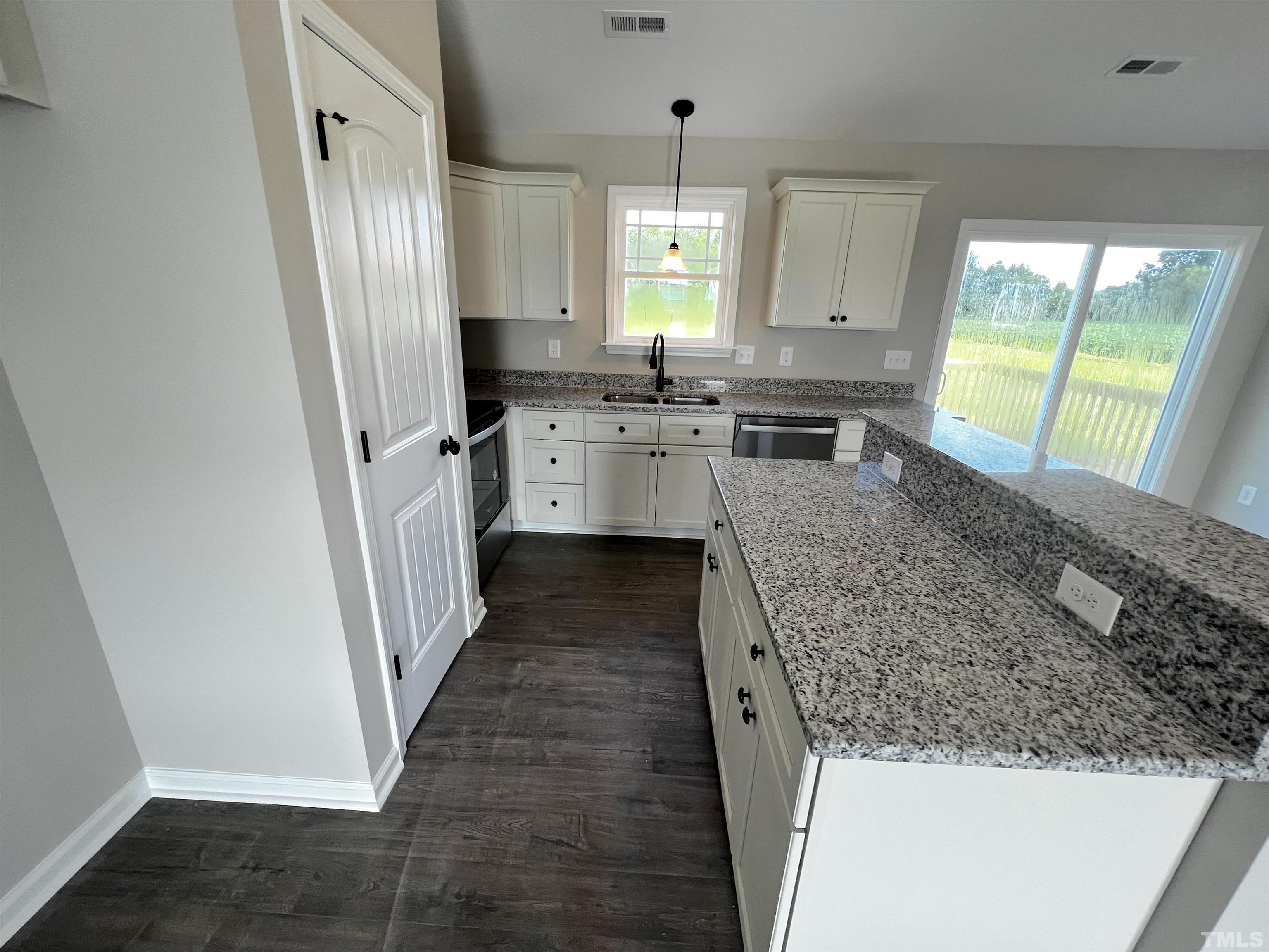 96 Mamie Road Benson, NC 27504 - Photo 7 of 20 a kitchen with white cabinets and window