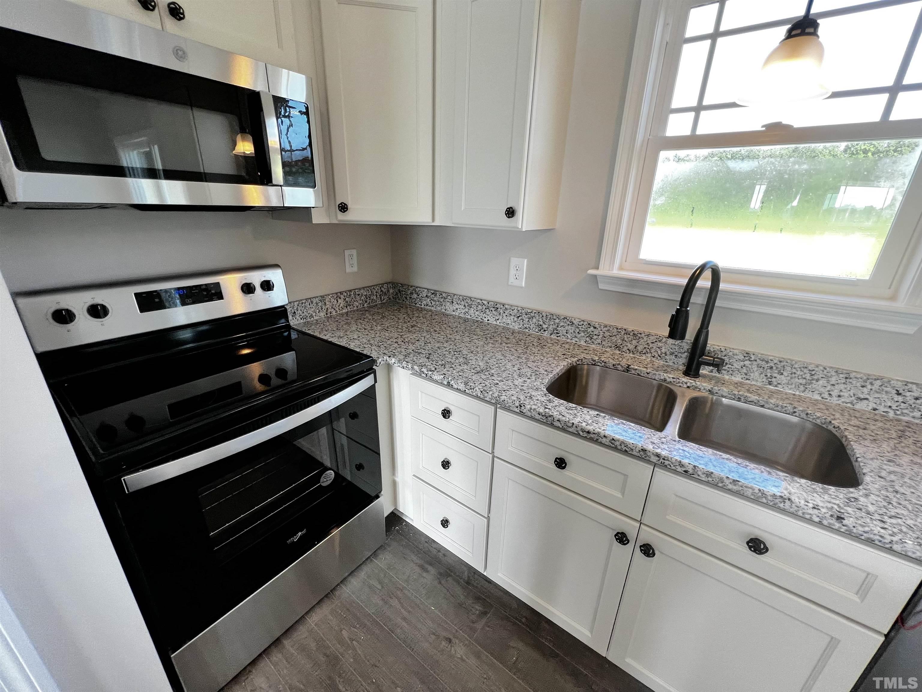 96 Mamie Road Benson, NC 27504 - Photo 8 of 20 a kitchen with stainless steel appliances white cabinets and a stove top oven