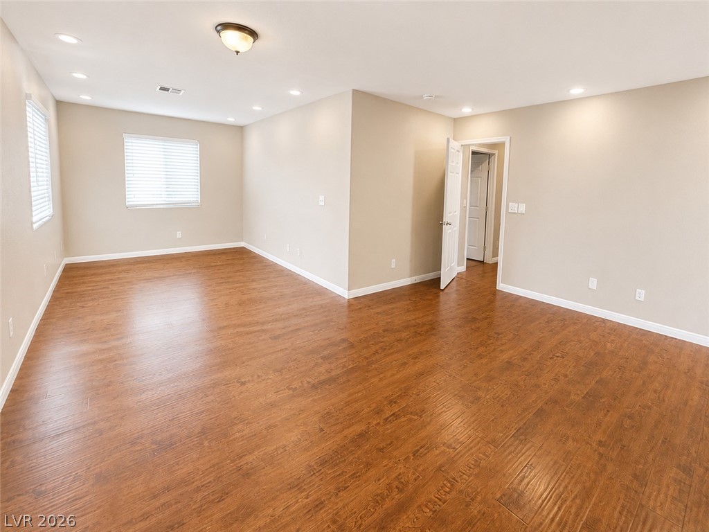 7213 London Bridge Avenue Las Vegas, NV 89130 - Photo 7 of 11 Bright and airy room featuring warm wooden floors and inviting recessed lighting.