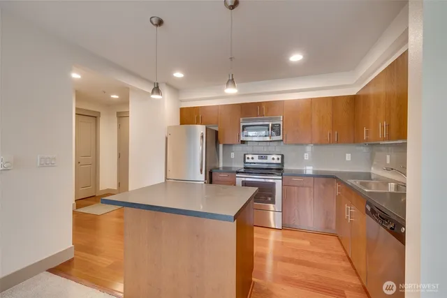 a kitchen with stainless steel appliances a refrigerator sink and stove