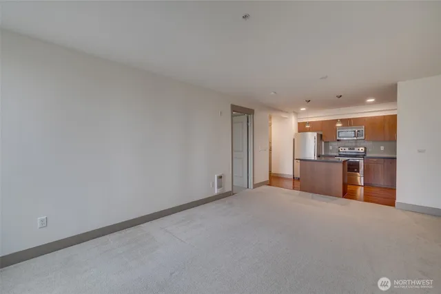 a view of an empty room with kitchen