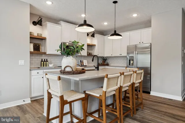 a kitchen with kitchen island granite countertop a sink a center island and cabinets