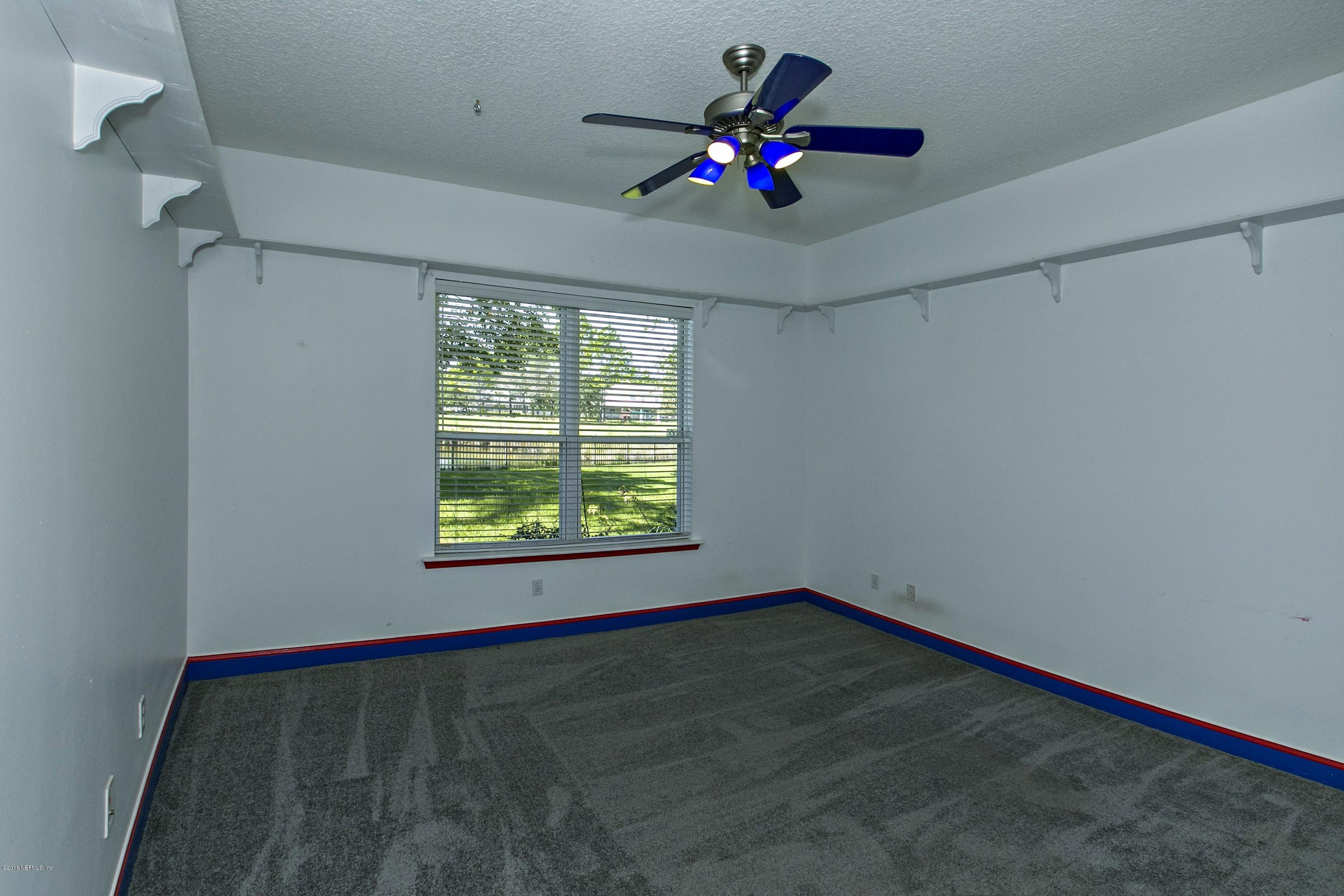 2156 West Quay Road St. Augustine, FL 32092 - Photo 17 of 51 an empty room with a chandelier fan and windows