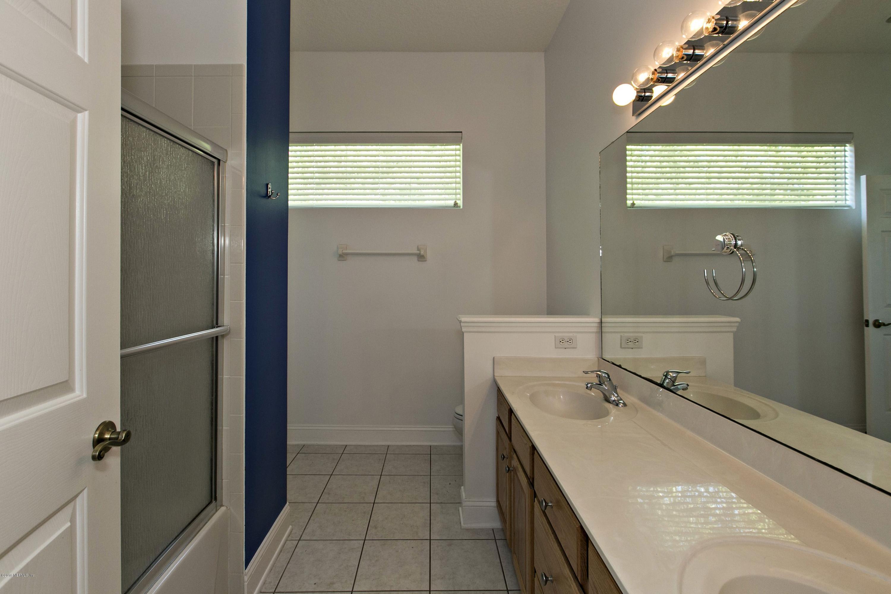 2156 West Quay Road St. Augustine, FL 32092 - Photo 18 of 51 a bathroom with a double vanity sink a mirror and a shower