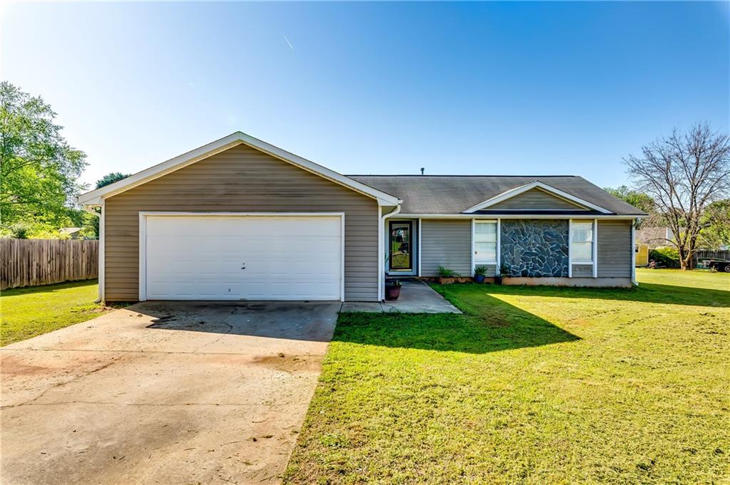 a front view of house with yard and garage