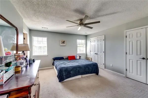 a spacious bedroom with a large bed a chandelier and a window