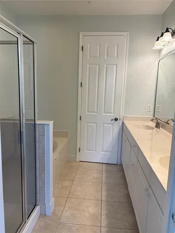 a bathroom with a granite countertop sink a mirror and a bathtub