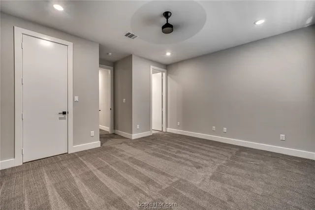 an empty room with windows and fan