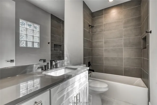 a bathroom with a granite countertop sink a toilet a mirror and shower