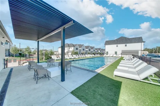 a view of a patio with couches and table and chairs under an umbrella