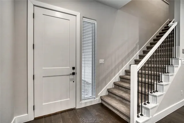 a view of staircase with white walls and railing