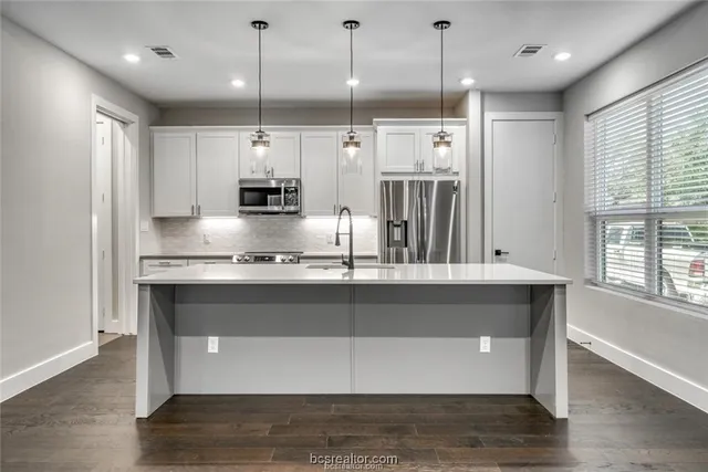 a kitchen with kitchen island granite countertop a stove a sink and a window