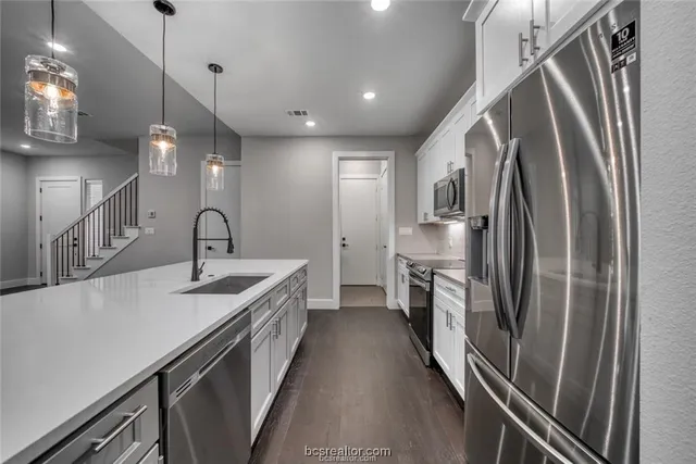 a kitchen with refrigerator a sink and stove