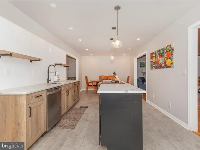 a kitchen with stainless steel appliances granite countertop a sink and dishwasher a refrigerator with wooden floor