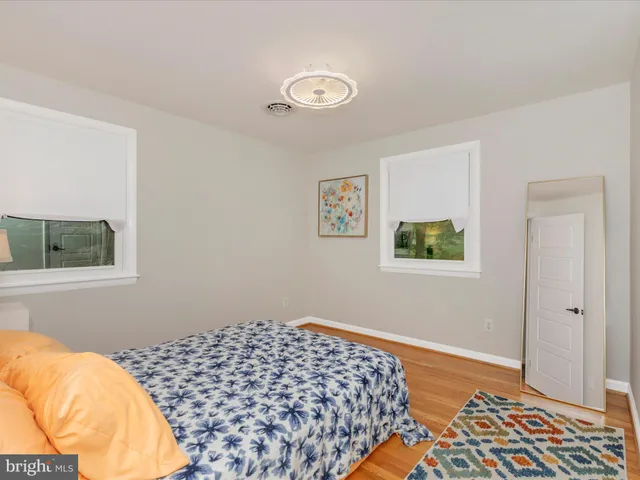 a bedroom with a bed and a lamp on the dresser