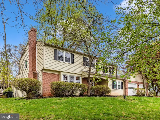 a view of a white house with a large tree