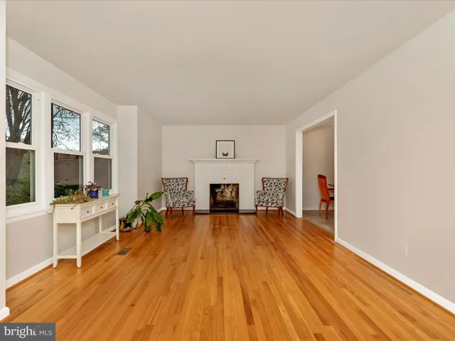 a view of a livingroom with furniture a fireplace and wooden floor