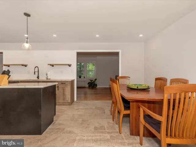 a kitchen with a table chairs sink and cabinets