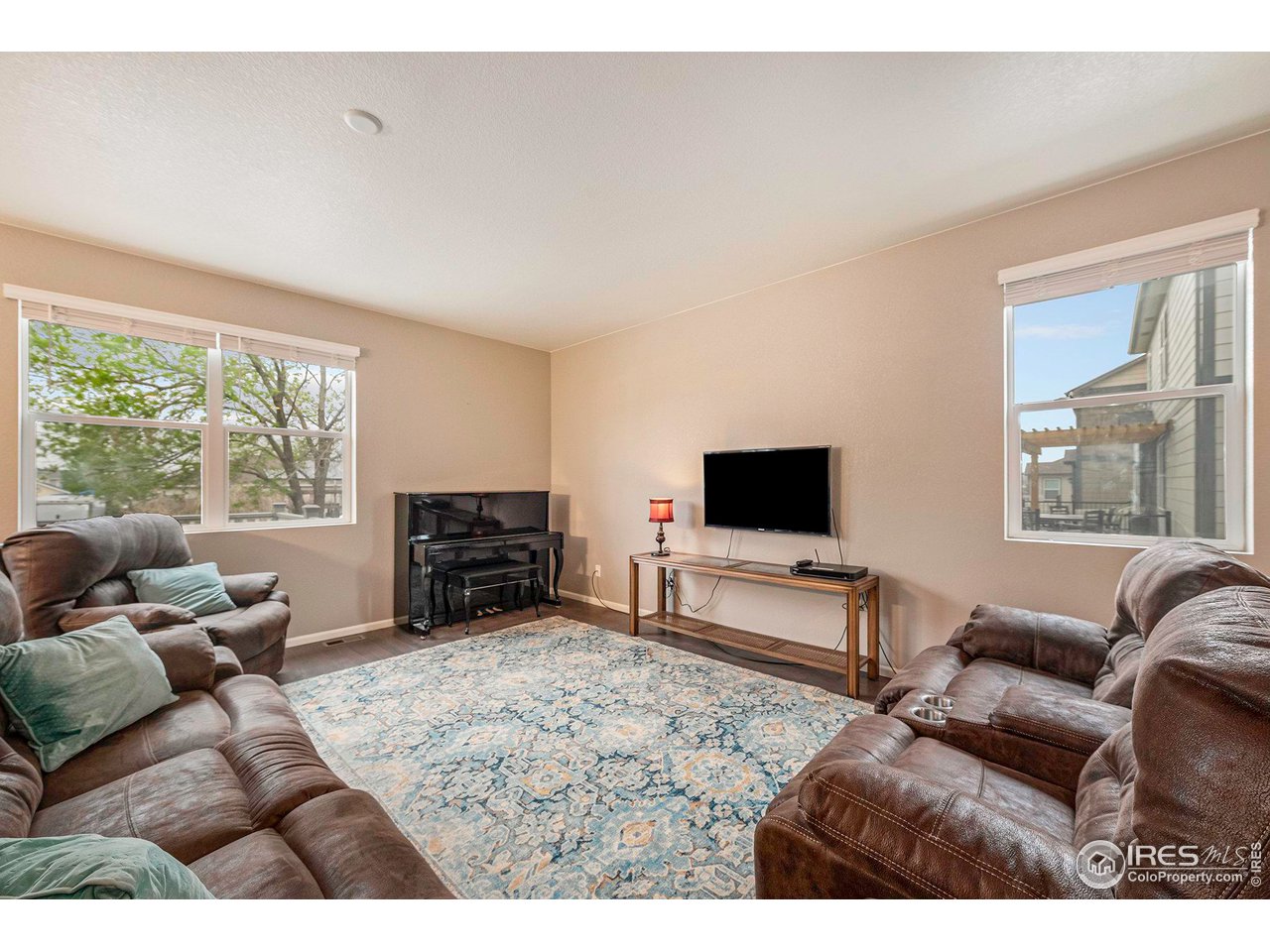 7005 Morrison Drive Frederick, CO 80530 - Photo 12 of 26 a living room with furniture a flat screen tv and a large window