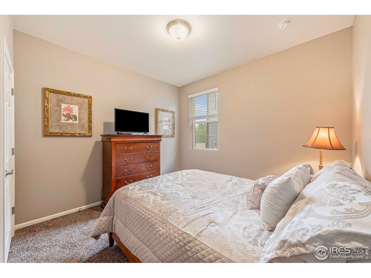 7005 Morrison Drive Frederick, CO 80530 - Photo 13 of 26 a bedroom with a bed and a flat screen tv