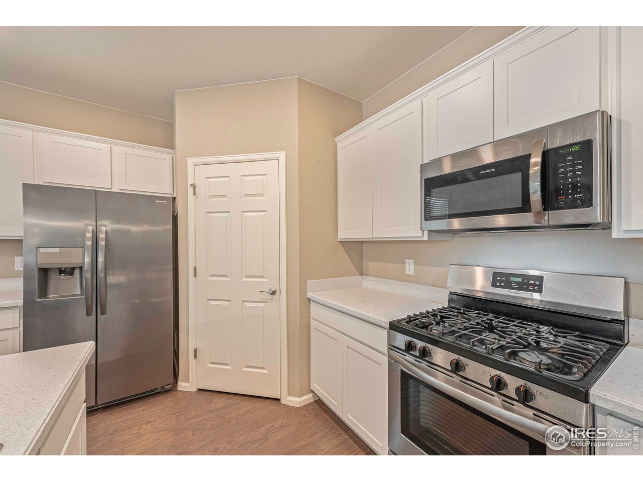 7005 Morrison Drive Frederick, CO 80530 - Photo 8 of 26 a kitchen with stainless steel appliances a stove a microwave and cabinets