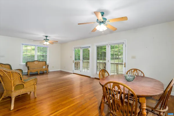 a view of a dining room with furniture a chandelier and wooden floor