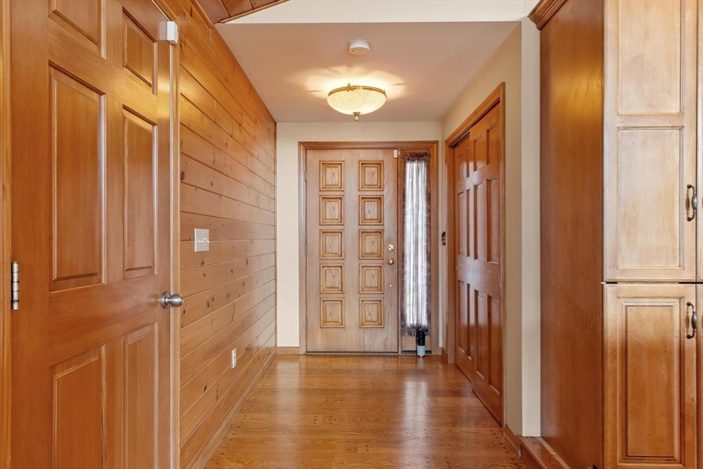 243 Concord Road Westford, MA 01886 - Photo 16 of 42 a view of a hallway with wooden floor and cabinet with a bathroom