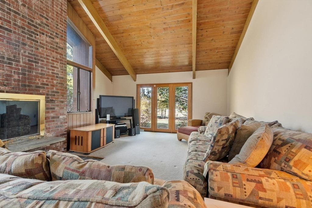 243 Concord Road Westford, MA 01886 - Photo 18 of 42 a living room with furniture a flat screen tv and a fireplace