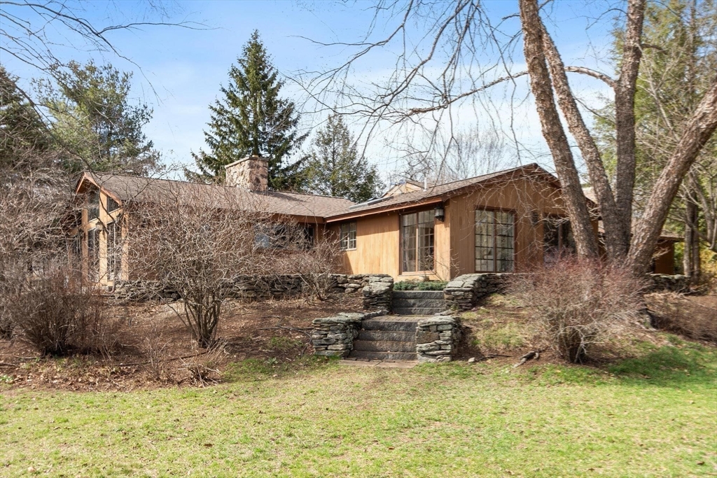 243 Concord Road Westford, MA 01886 - Photo 34 of 42 a backyard of a house with large trees and outdoor seating