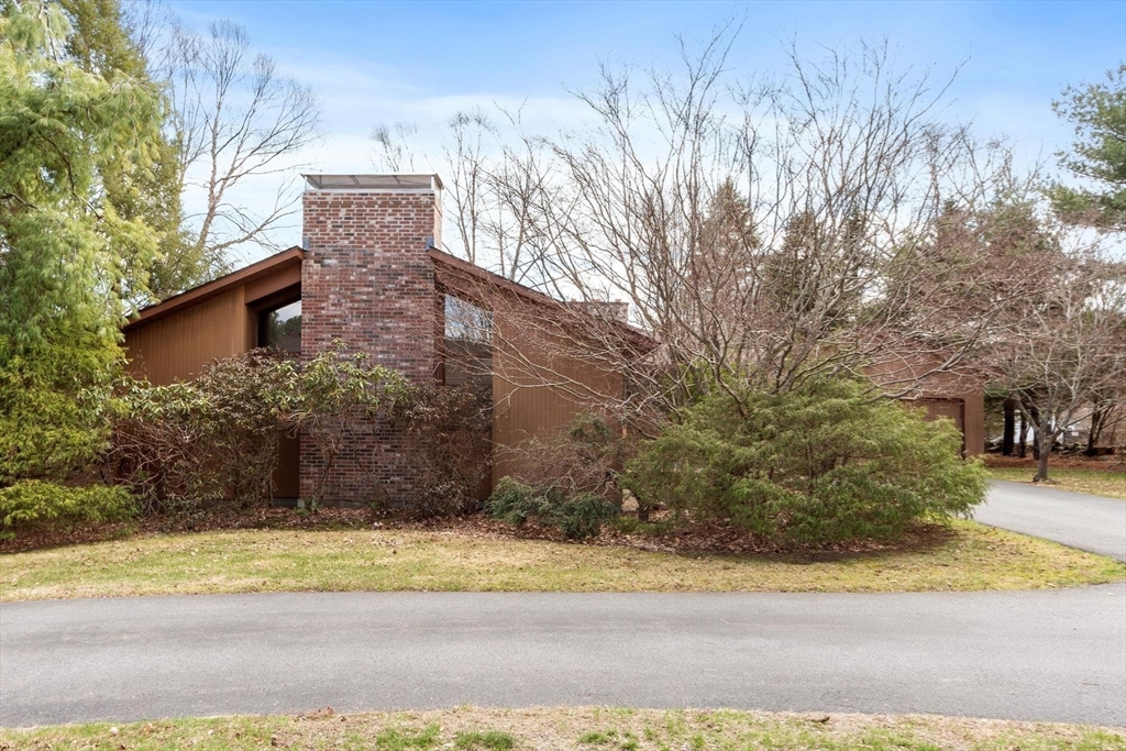 243 Concord Road Westford, MA 01886 - Photo 4 of 42 a view of a brick house with a yard next to a road