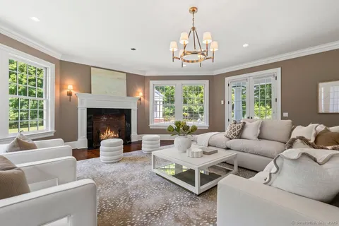 a living room with furniture chandelier and a fireplace