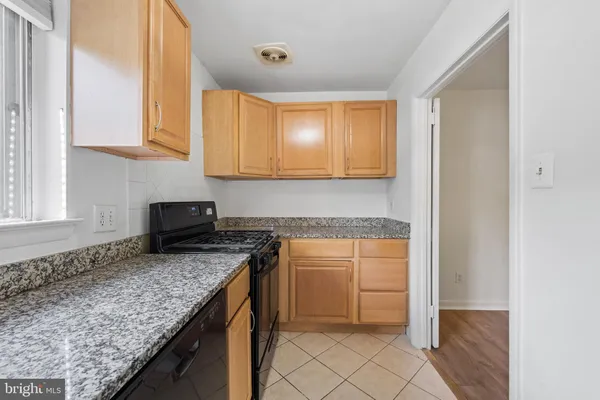a kitchen with granite countertop a sink a stove and cabinets