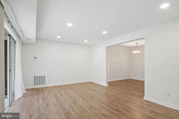 an empty room with wooden floor and entrance