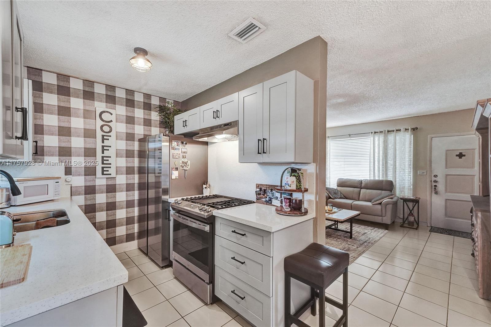 534 West 53rd Terrace Hialeah, FL 33012 - Photo 14 of 34 a kitchen with a stove cabinets and a table