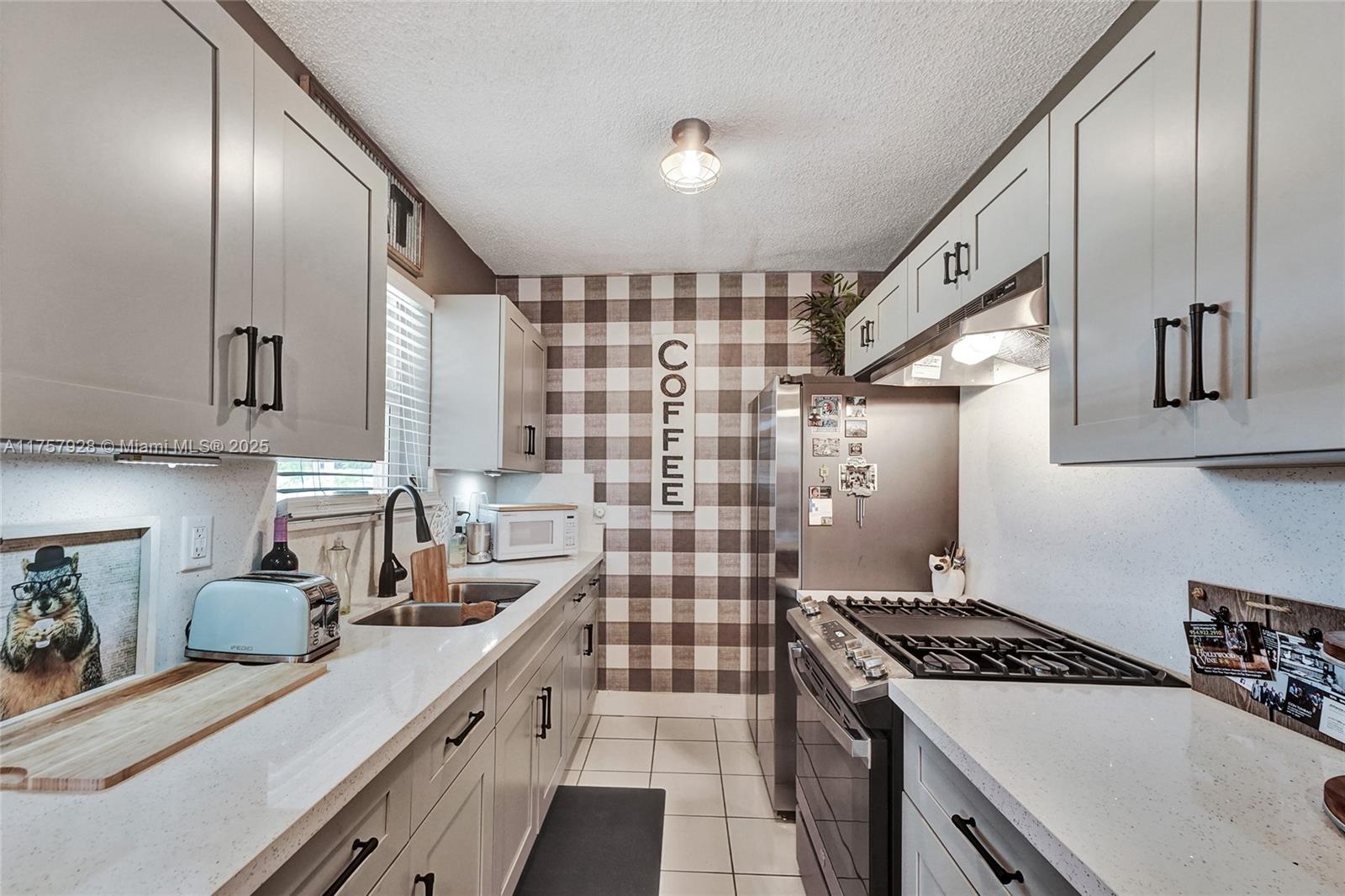 534 West 53rd Terrace Hialeah, FL 33012 - Photo 16 of 34 a kitchen with a stove and a sink