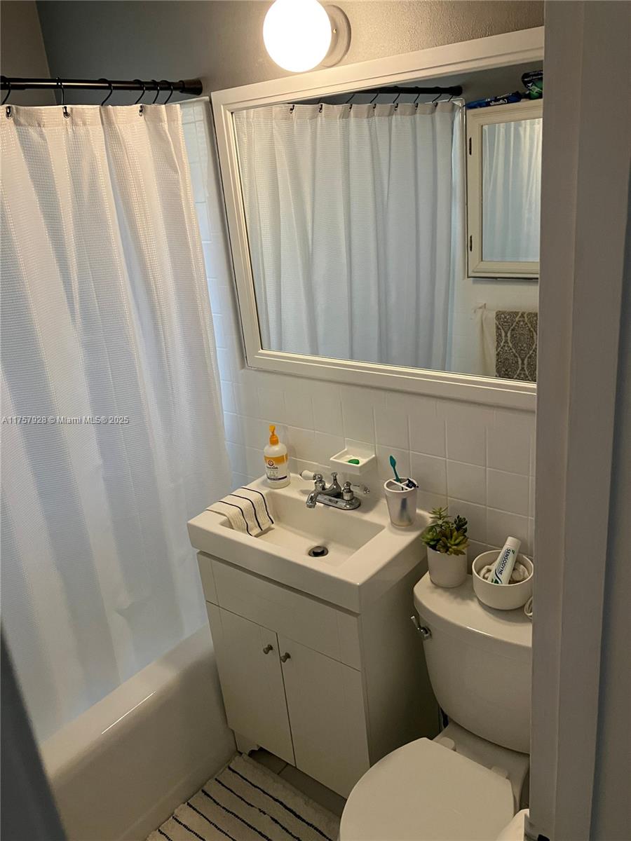 534 West 53rd Terrace Hialeah, FL 33012 - Photo 34 of 34 a bathroom with a sink a toilet and shower curtain