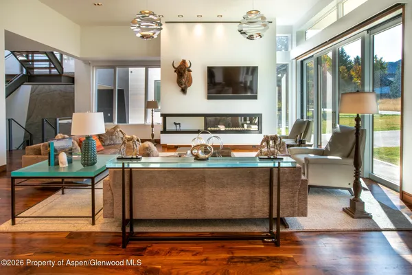 a living room with furniture a large window and a flat screen tv