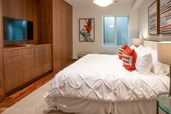 a bedroom with a bed and a flat screen tv