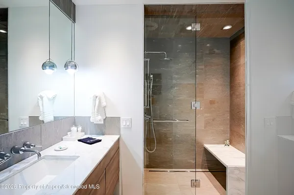 a bathroom with a double vanity sink mirror and shower