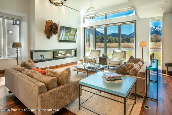 a living room with furniture and a floor to ceiling window