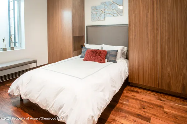 a large bed sitting in a bedroom next to a cabinet