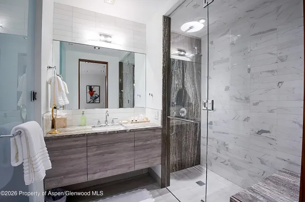 a bathroom with a granite countertop sink mirror and shower