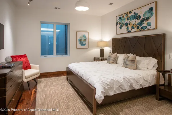 a bedroom with bed and wooden floor