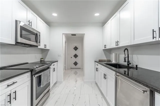 a kitchen with a sink stove and microwave