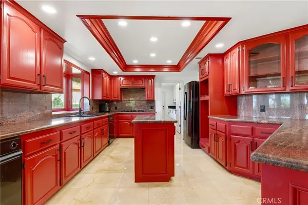 a kitchen with stainless steel appliances granite countertop a refrigerator a sink dishwasher a stove and oven with wooden cabinets