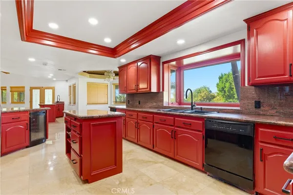 a kitchen with stainless steel appliances granite countertop wooden cabinets a sink and dishwasher a stove next to a window