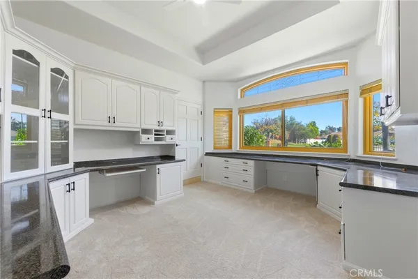 a bathroom with a granite countertop sink a toilet and a mirror