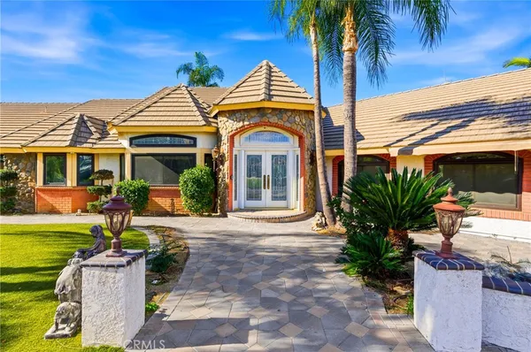 a front view of a house with a garden and patio