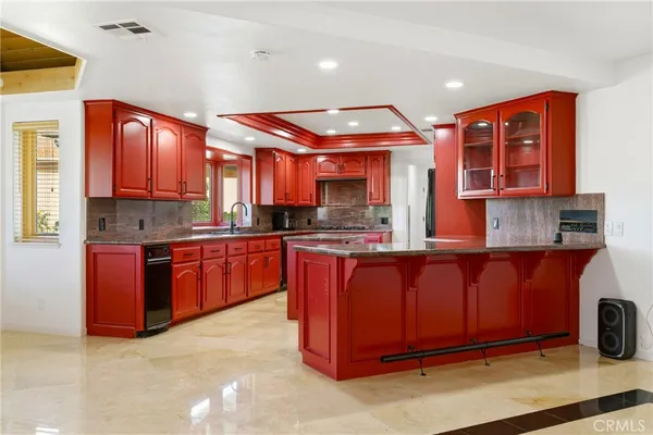 a kitchen with stainless steel appliances granite countertop wooden cabinets a stove top oven a sink and dishwasher
